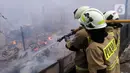 Petugas pemadam berusaha memadamkan api yang membakar pemukiman warga di kawasan Jalan Kebayoran Lama, Jakarta, Minggu (30/10/2022). Sebanyak 20 unit mobil damkar dikerahkan. Total sekitar 100 personel yang turun ke lokasi memadamkan api. (Liputan6.com/Helmi Fithriansyah)