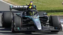 Pembalap Mercedes, Lewis Hamilton memegang bendera Inggris saat melakukan victory lap pada Formula 1 GP Inggris 2024 yang berlangsung di Sirkuit Silverstone, Inggris, Minggu (08/07/2024). (AFP/Luca Bruno)
