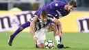 Pemain Juventus, Paulo Dybala (bawah) berebut bola dengan pemain Fiorentina, Davide Astori pada  lanjutan Serie A di Allianz Stadium, Turin, (20/9/2017). Juventus menang 1-0. (Alessandro Di Marco/ANSA via AP)