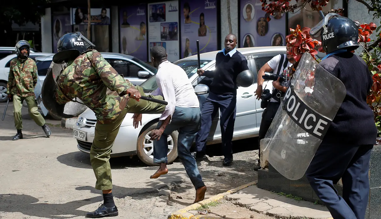 Polisi berusaha menendang demonstran saat bentrokan di Nairobi, Kenya (16/5). Demonstran menuntut pembubaran otoritas pemilu karena adanya dugaan korupsi. (REUTERS/Goran (REUTERS/Goran Tomasevic)