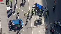 Paramedis memberikan pertolongan setelah sebuah mobil menabrak kerumunan pejalan kaki di Flinders Street, salah satu ikon kota Melbourne, Kamis (21/12). Flinders Street adalah salah satu ruas jalan tersibuk di Melbourne (Australian Broadcast Corp. via AP)