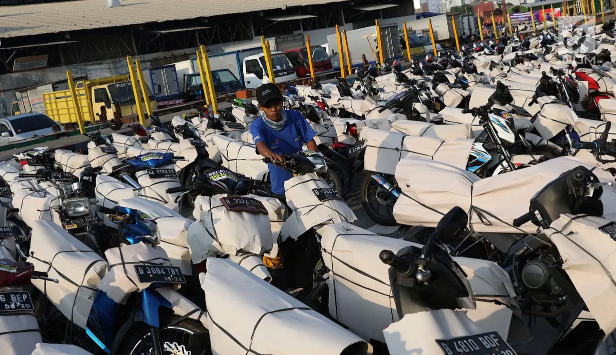 Petugas mengemas sepeda motor untuk diangkut dengan kereta api Stasiun Kampung Bandan, Jakarta, Senin (11/6). Program mudik gratis ini digagas Kemenhub tersebut melayani pengiriman ke beberapa daerah di Pulau Jawa. (Liputan6.com/Immanuel Antonius)