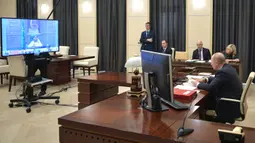 Presiden Rusia Vladimir Putin (kanan) saat mengikuti KTT Luar Biasa G20 secara virtual dari Moskow, Rusia, Kamis (26/3/2020). Para pemimpin dunia mengkoordinasikan respons global terhadap pandemi virus corona COVID-19. (Alexei Druzhinin, Sputnik, Kremlin Pool Photo via AP)
