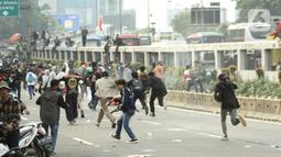 Massa aksi demo mahasiswa berlari menghindari tembakan gas air mata oleh aparat keamanan di depan Gedung DPR, Jakarta, Senin (11/4/2022). Mahasiswa yang tergabung dalam aliansi BEM SI menggelar unjuk rasa besar-besaran di depan Gedung DPR/MPR RI, Senin ini. (Liputan6.com/Angga Yuniar)
