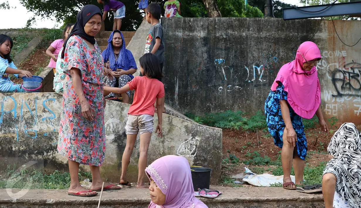 Sejumlah ibu bersama anaknya mencari ikan dan udang di bantaran Kanal Banjir Timur, Cipinang Muara, Jakarta, Selasa (16/5). Kegiatan itu dilakukan para ibu dan anak-anaknya untuk mengisi masa libur sekolah. (Liputan6.com/Immanuel Antonius)