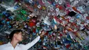Seorang pria melihat instalasi seni gantung sekelompok seniman yang terbuat dari sisa-sisa plastik, kaleng dan wadah di sebuah pameran "Reduce the Litter" di Pusat Kebudayaan Prancis di Hanoi (15/7/2019). Pameran ini mengambil perspektif tentang produksi dan konsumsi. (AFP Photo/Nhac Nguyen)