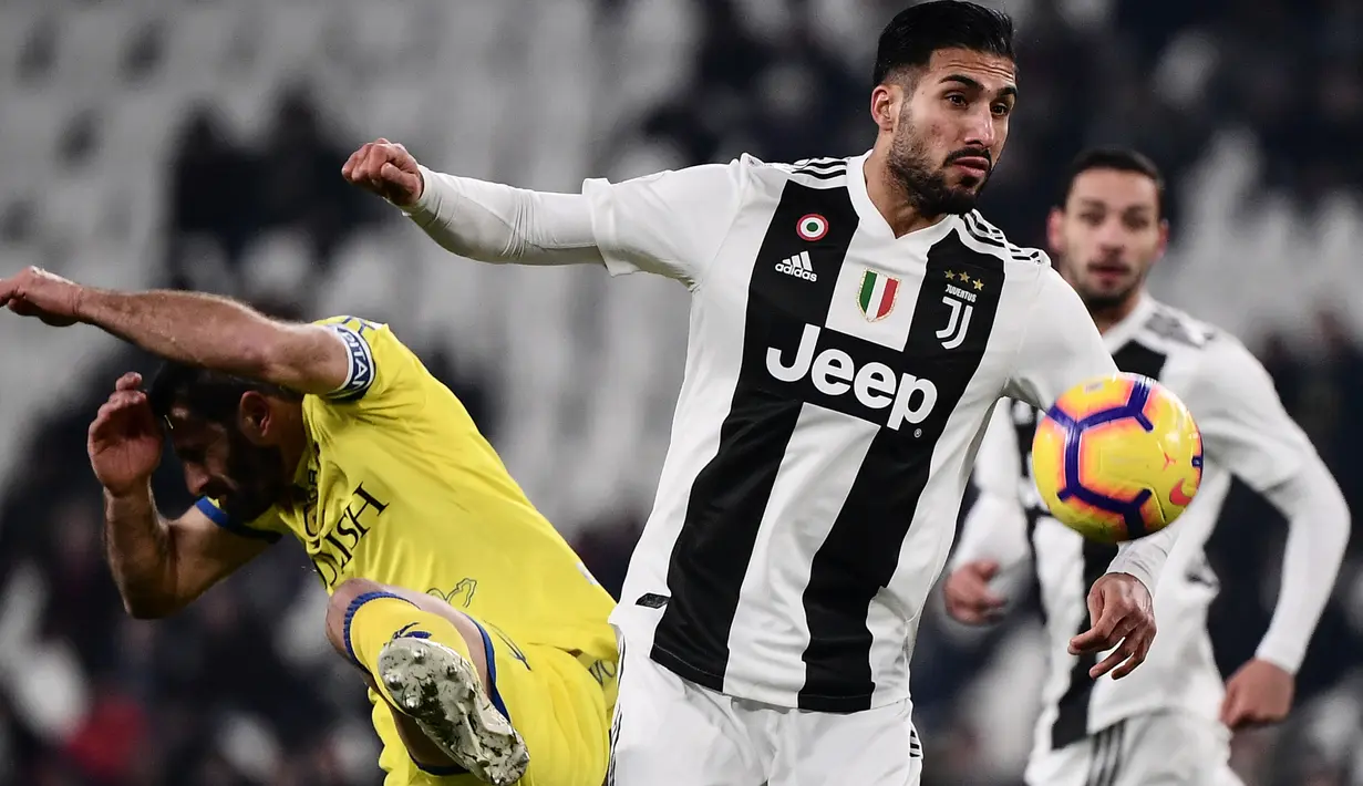 Pemain Chievo, Sergio Pellissier berebut bola dengan gelandang Juventus, Emre Can pada laga pekan ke-20 Serie A di Allianz Stadium, Senin (21/1). Juventus berhasil memantapkan posisi di puncak klasemen setelah menggilas Chievo 3-0. (Marco BERTORELLO/AFP)