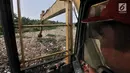 Petugas dari Dinas Lingkungan Hidup Kabupaten Bekasi menggunakan kendaraan alat berat mengeruk sampah yang memenuhi Kali Pisang Batu, Tarumajaya, Bekasi, Jawa Barat, Rabu (9/1). (Merdeka.com/Iqbal S. Nugroho)