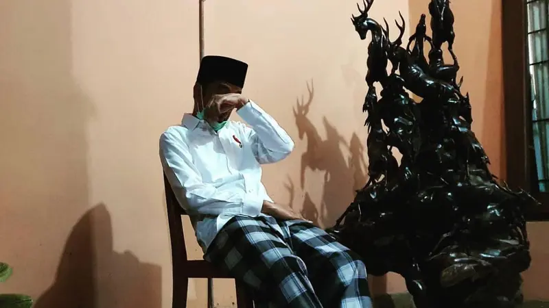 Jokowi terlihat duduk seorang diri di teras rumah ibunda di Solo, Jawa Tengah.