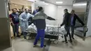 Wartawan dan petugas medis membawa jenazah wartawan Al Jazeera Shireen Abu Akleh ke kamar mayat rumah sakit di Kota Jenin, Tepi Barat, Rabu (11/5/2022). Menurut Kementerian Kesehatan Palestina, Shireen Abu Akleh tewas ditembak saat meliput serangan Israel di Kota Jenin. (AP Photo/Majdi Mohammed)