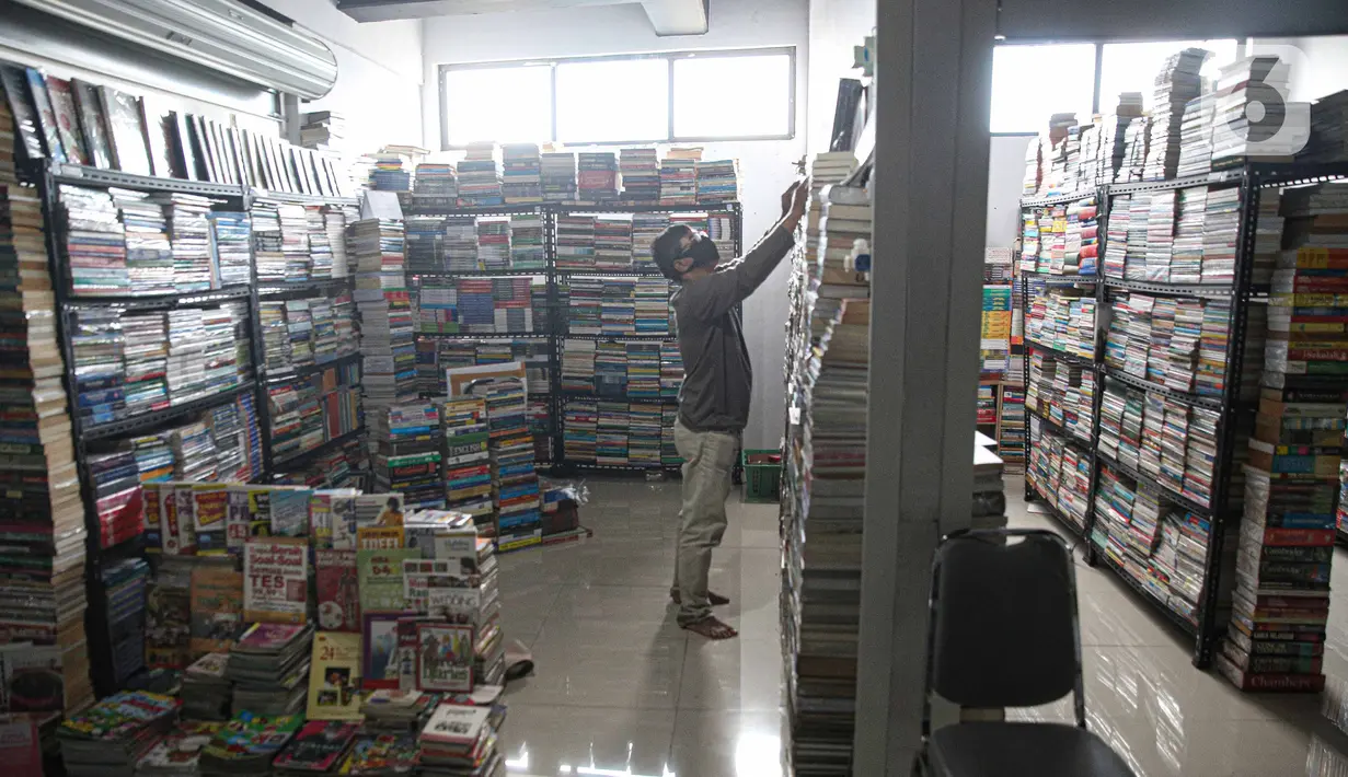 Pedagang merapikan buku bacaan di Pasar Kenari, Jakarta, Rabu (24/11/2021). Semua toko yang berada di lantai 3 merupakan toko subsidi dari pemerintah.  (Liputan6.com/Faizal Fanani)