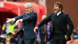 Pelatih Stoke City, Mark Hughes (kiri) dan pelatih Chelsea, Antonio Conte memberi intruksi ke para pemainya saat bertanding pada lanjutan Liga Inggris di Stadion Bet365 di Stoke-on-Trent, (23/9). Chelsea menang 4-0 atas Stoke. (AFP Photo/Lindsey Parnaby)