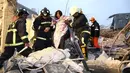 Petugas penyelamat membantu wanita di bangunan yang rusak akibat gempa 6,4 SR  di Tainan, (6/2). Gempa terjadi pukul 4 subuh tadi telah menghancurkan beberapa apartemen di kawasan Wei Guan, Tainan, Taiwan. (REUTERS/Stringer)