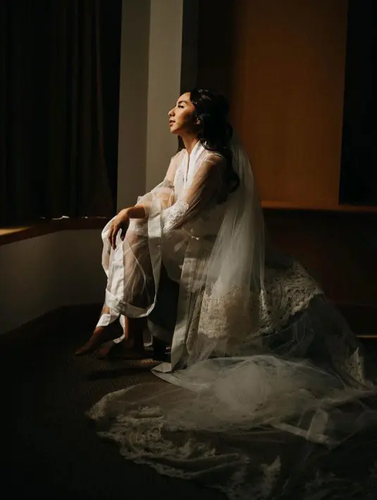 Clay juga mengenakan robe pengantin simple dengan inner brokat pendek dilapisi kimono transparan serba putih. (Instagram/knots.robes).