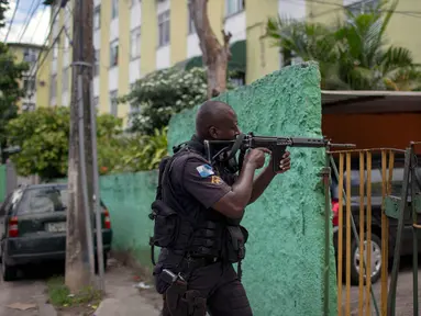 Seorang polisi militer melakukan operasi penggerebekan di daerah kumuh Cidade de Deus di Rio de Janeiro, Brasil (1/2). Daerah Cidade de Deus dikenal sebagai kampungnya para gembong dan penyelundup narkotika. (AFP Photo/Mauro Pimentel)