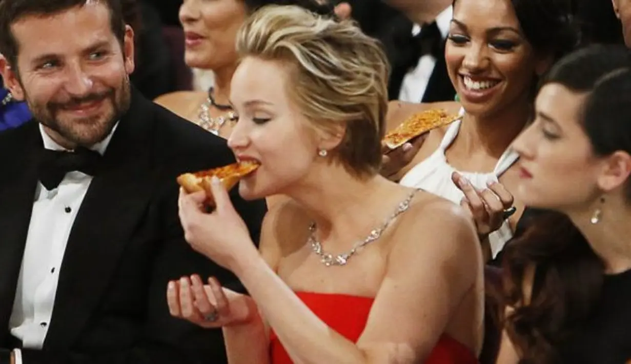 Jennifer Lawrence bahkan tertangkap makan pizza dengann lahap saat Oscar loh! (livetradingnews.com)