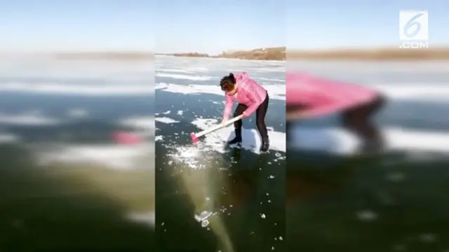 Dua wanita memecahkan sungai yang beku di China. Aksi tersebut mereka lakukan agar dapat mengambil ikan raksasa yang berada di bawahnya.