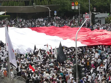 Peserta aksi massa Gerakan Nasional Kedaulatan Rakyat mengibarkan bendera Merah Putih raksasa saat melakukan unjuk rasa di perempatan dekat Gedung Bawaslu, Jakarta, Rabu (22/5/2019). Dalam aksinya mereka meminta Bawaslu memeriksa kembali hasil Pemilu 2019. (Liputan6.com/Helmi Fithriansyah)