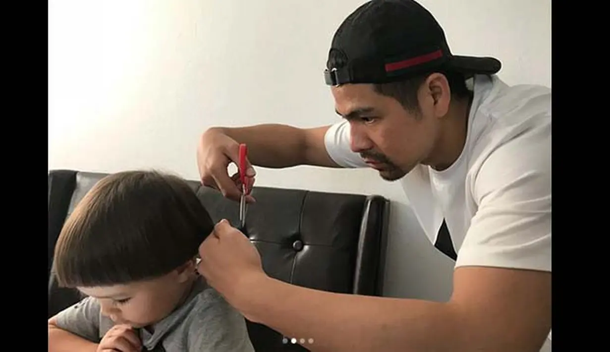 Dari foto ini terlihat kalau Erick dan El sama-sama serius. Erick begitu serius memotong rambutnya, sedangkan El yang diam saja sambil mengamati layar ponsel pintarnya. (Instagram/erickbanaiskandar)