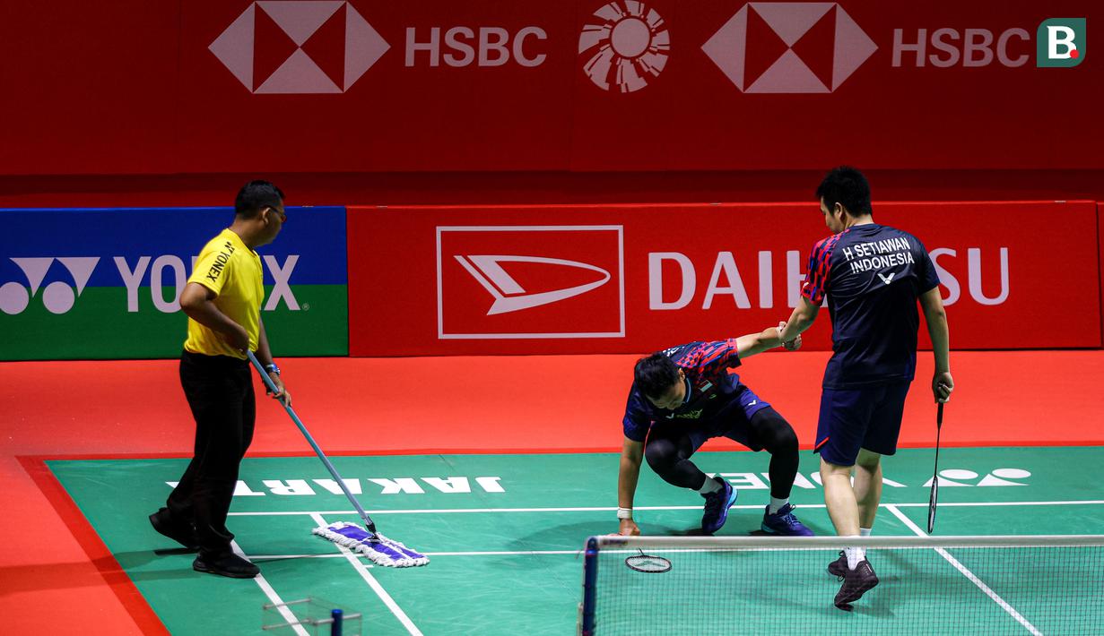 Ganda putra Indonesia, Hendra Setiawan membantu Mohammad Ahsan berdiri saat melawan wakil Taiwan, Chiang Chien-Wei/Wu Hsuan-Yi pada babak 32 besar Indonesia Masters 2025 di Istora Senayan, Jakarta, Selasa (21/1/2025) sore WIB. (Bola.com/Bagas lazuardi)
