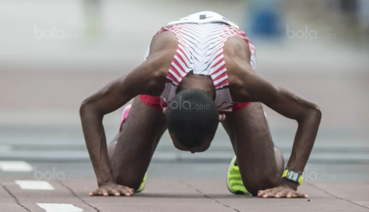 Pelari Indonesia, Agus Prayogo, sujud usai tampil pada nomor marathon SEA Games di Putrajaya, Kuala Lumpur, Sabtu (19/8/2017). Agus meraih medali perak dengan waktu dua jam 27 menit 16 detik. (Bola.com/Vitalis Yogi Trisna)