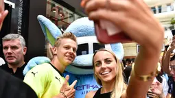 Penggemar wanita berselfie dengan pemain Manchester City  Oleksandr Zinchenko selama acara promosi di Hong Kong (23/7/2019). The Citizens akan menghadapi Kitchee SC dalam laga uji cobadi Hong Kong Stadium pada 24 Juli 2019. (AFP Photo/Anthony Wallace)