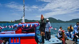 Nelayan yang tergabung dalam wilayah Panglima Laot Lok Kuala Cangkoi bersama warga mengikuti pawai kapal hias pada tradisi kenduri laut di Ulee Lheu, Banda Aceh, Aceh, Rabu (22/7/2026). (AFP/ Chaideer Mahyuddin)