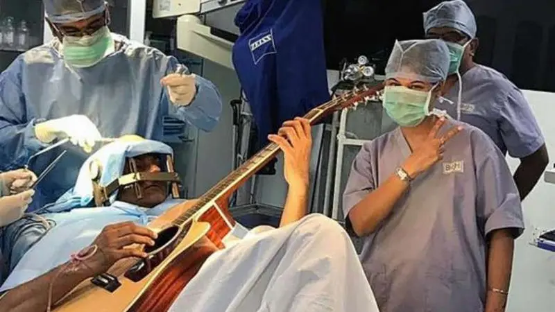 Abhishek Prasad (37) menjalani operasi otak sambil bermain gitar. Cara ini dinilai membantu dalam proses penyembuhan (AFP)
