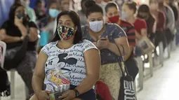 Sejumlah wanita duduk setelah menerima sumbangan pembalut dan perlengkapan kebersihan perempuan lainnya di tengah pandemi COVID-19 di favela Paraisopolis, di Sao Paulo, Brasil (24/5/2021). Sumbangan ini disediakan oleh LSM lokal "G10 Favelas". (AP Photo/Andre Penner)