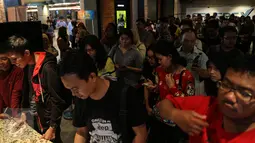 Ratusan orang mengantri untuk mendapatkan tiket nonton bareng Minions yang diselenggarakan oleh CinemaHolic di Blitz Megaplex, Jakarta, Minggu (28/6/2015). (Liputan6.com/Faizal Fanani)