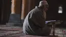 Seorang umat Muslim membaca Al-Quran selama bulan suci Ramadhan di dalam masjid Jamia di Srinagar (20/4/2021). Masjid Jamia Srinagar dianggap sebagai salah satu masjid terpenting di Kashmir. (AFP/ Tauseef Mustafa)