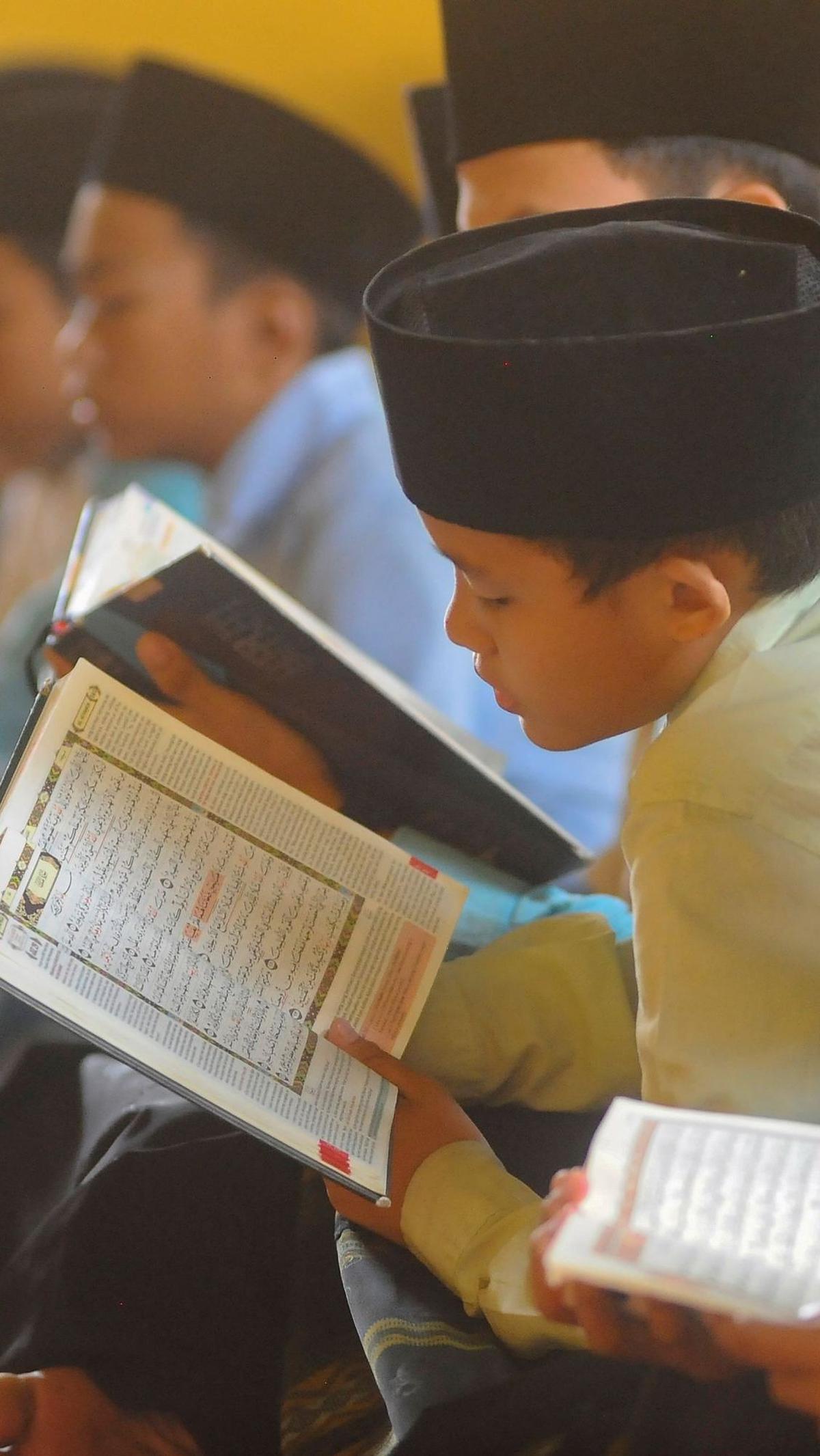 Wajah-wajah mereka tampak penuh ketenangan dan khidmat, menunjukkan kecintaan mereka terhadap kitab suci umat Islam.&nbsp;Foto: merdeka.com / Arie Basuki