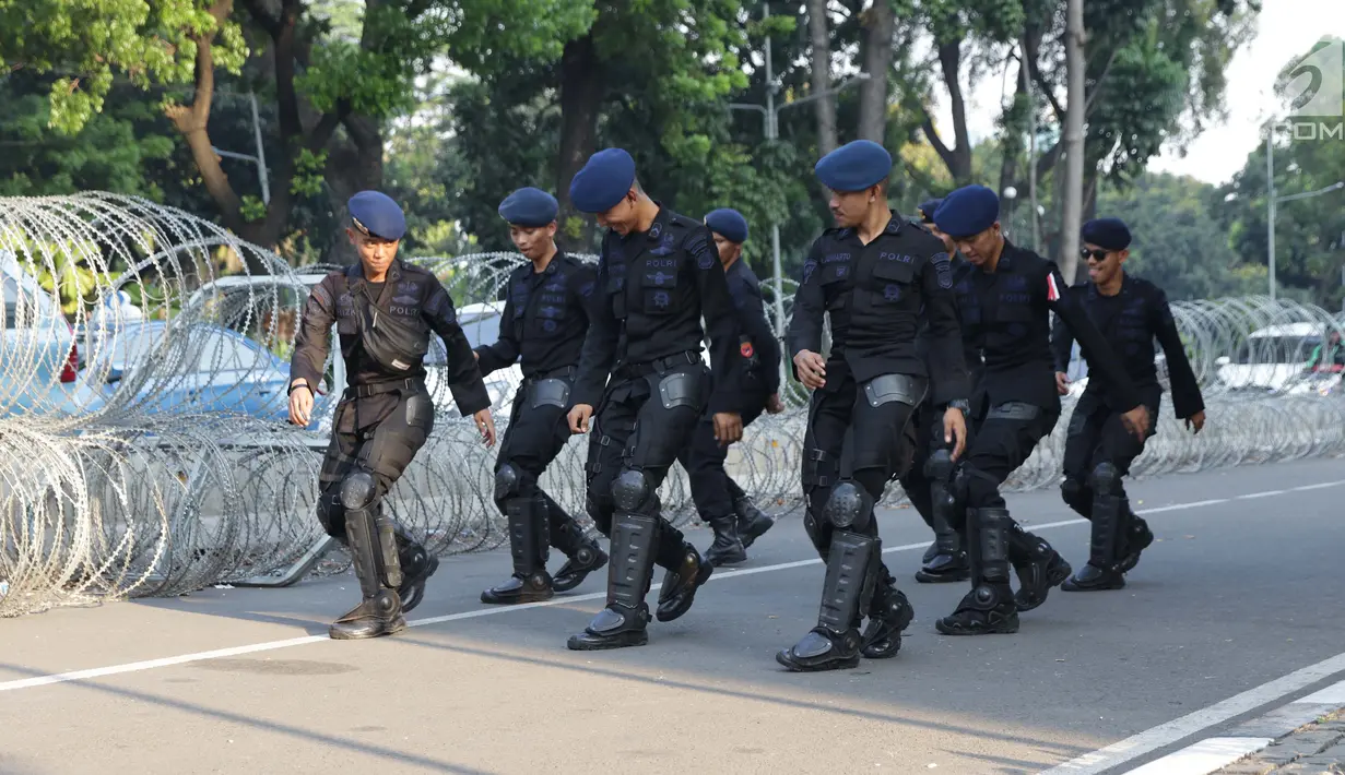 Personel Brimob menari bersama disela-sela berjaga di depan Gedung Mahkamah Konstitusi (MK), Jakarta, Selasa (25/6/2019). Kegiatan ini dilakukan untuk mengusir kejenuhan disela-sela pengamanan Gedung MK jelang sidang pembacaan putusan, Kamis (27/6). (Liputan6.com/Helmi Fithriansyah)