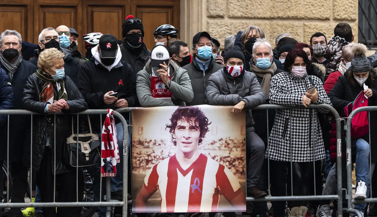 Pendukung memberikan penghormatan kepada mendiang pemain sepak bola Italia Paolo Rossi selama pemakamannya di luar Katedral Santa Maria Annunciata di Vicenza, Italia (12/12/2020). Paolo Rossi meninggal di usia 64. (AFP/Marco Bertorello)