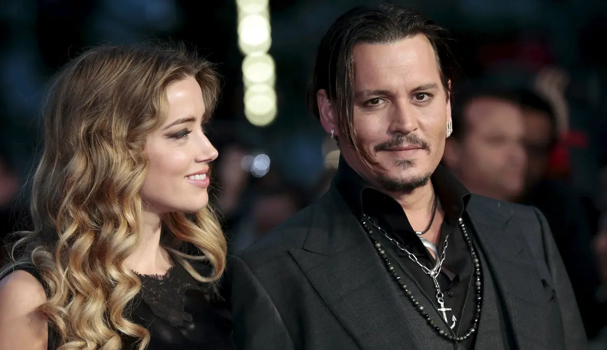 Aktor Johnny Depp (kanan) saat didampingi istrinya Amber Heard dalam pemutaran perdana film "Black Mass " di London, Inggris, Minggu (11/10/2015).Aktor 52 tahun ini terkenal setelah membintangi film Pirates of Caribbean. (REUTERS/Suzanne Plunkett)