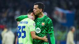 Kiper Barcelona, Wojciech Szczesny, berusaha menenangkan Gerard Martin, yang menangis setelah takluk dari Inter Milan dalam duel leg kedua semifinal Liga Champions di Stadion Giuseppe Meazza, Milan, Rabu (7/5/2025) dini hari WIB. (AFP/Piero Cruciatti)