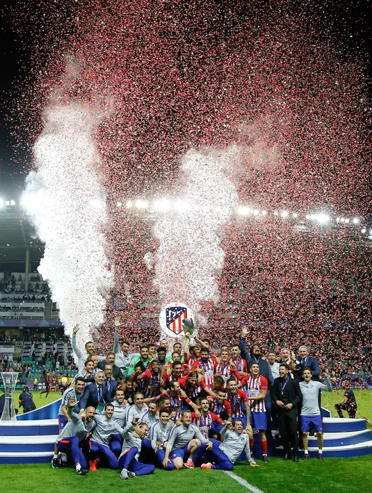 Para pemain dan tim Atletico Madrid berselebrasi meraih Piala Super Eropa setelah melawan Real Madrid di Lillekula Stadium di Tallinn, Estonia, (15/8). Atletico Madrid berhasil mengalahkan Real Madrid dengan skor telak 4-2. (AP Photo/Pavel Golovkin)