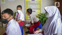 Sejumlah murid sekolah dasar menunggu untuk menerima vaksinasi COVID-19 di SDN 04 Pagi Cilandak Barat, Jakarta, Selasa (14/12/2021). Pemerintah lewat Kementerian Kesehatan mulai memberikan vaksinasi COVID-19 untuk anak usia 6-11 tahun. (Liputan6.com/Faizal Fanani)