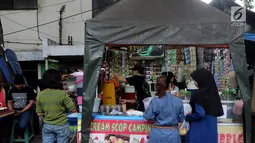 Pedagang melayani pembeli di Pasar Takjil Kebon Kacang, Jakarta, Senin (29/5). Meski berada di gang sempit, pasar tersebut menjadi lokasi favorit warga yang akan membeli makanan untuk hidangan berbuka puasa. (Liputan6.com/Johan Tallo)