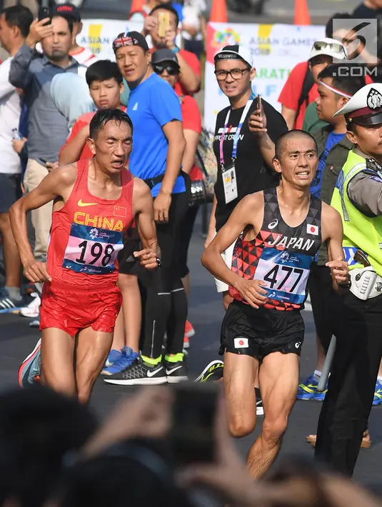 Atlet maraton memasuki garis finis di jalan Sudirman pada lomba Asian Games 2018 di Jakarta, Sabtu (25/8). Cabang nomor lari maraton menempuh jarak kurang lebih 42 kilometer dimenangkan pelari asal Jepang Hiroto Inoue. (Merdeka.com/Imam Buhori)