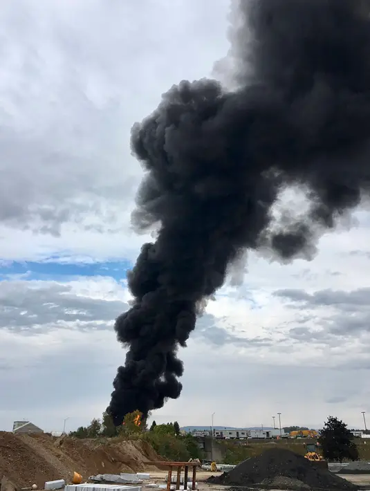 Asap hitam membumbung setelah pesawat pengebom era Perang Dunia II milik Amerika Serikat jatuh di Bandara Internasional Bradley, Connecticut, Rabu (2/10/2019). Hingga kini, belum diketahui penyebab kecelakaan namun, pesawat ini memang sudah tua. (Antonio Arreguin via AP)