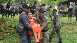 Petugas mengevakuasi seorang wanita saat pembongkaran bangunan vila ilegal di Kawasan Hutan Blok Cisadon, Bogor Selasa (24/4). Pembongkaran ini tindak lanjut putusan MA yang menyatakan Blok Cisadon merupakan kawasan hutan negara (Merdeka.com/Arie Basuki)