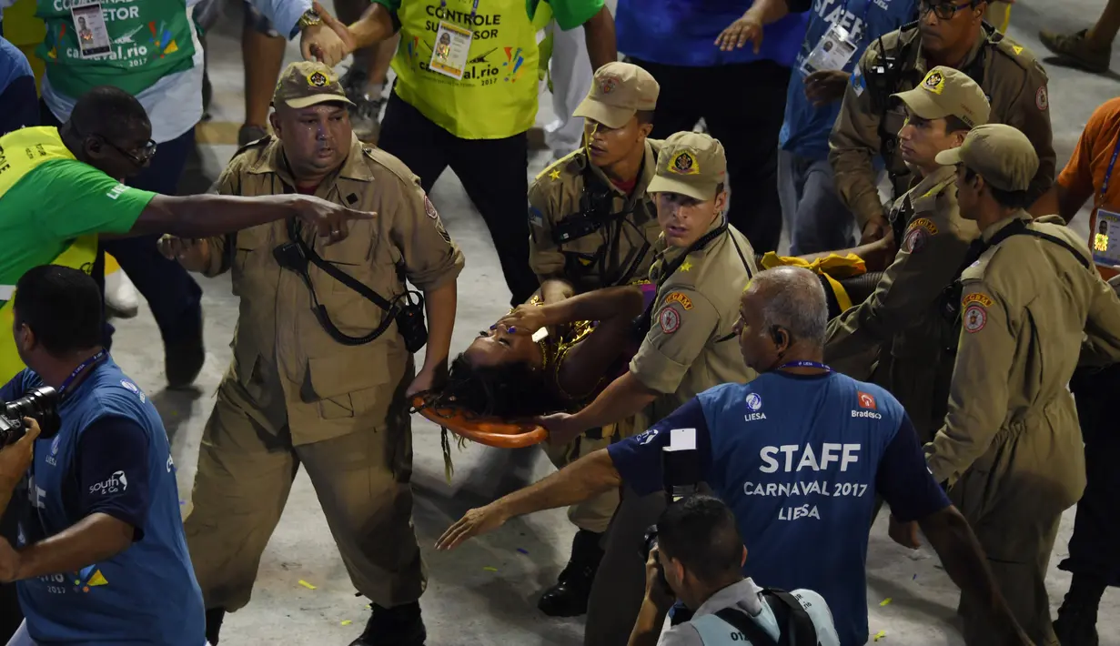Petugas pemadam kebakaran mengevakuasi penari dari sekolah samba Unidos da Tijuca yang menjadi korban akibat runtuhnya lantai tiga mobil pawai yang digunakan saat mengikuti Rio Carnival di Rio de Janeiro, Brasil (28/2). (AFP PHOTO/Vanderlei Almeida)