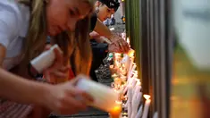 Para pelajar menyalakan lilin saat mengenang korban penembakan di luar Masjid Al Noor, Christchurch, Selandia Baru, Senin (18/3). Penembakan tersebut merupakan serangan terburuk dalam sejarah Selandia Baru modern. (AP Photo/Vincent Yu)