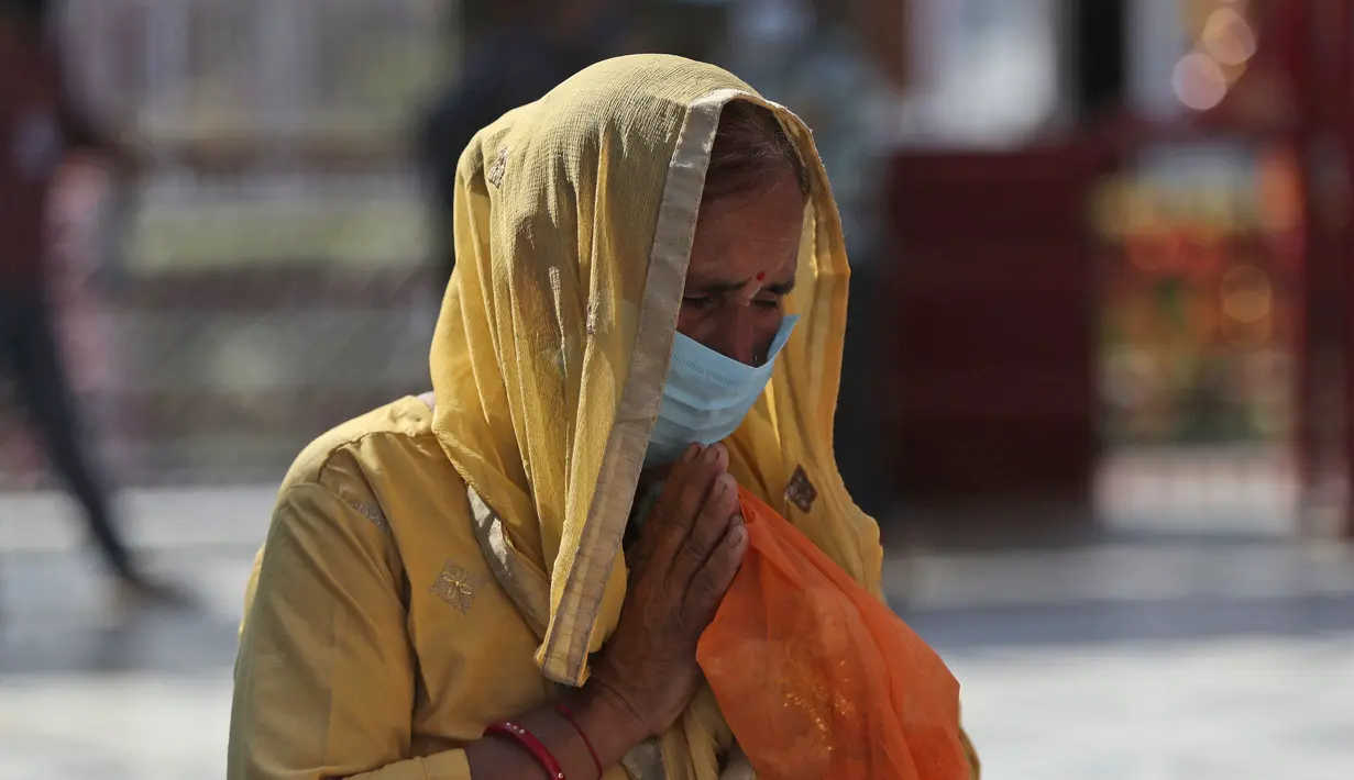 Umat Hindu yang mengenakan masker untuk mencegah penyebaran COVID-19 saat berdoa dalam kuil di Jammu, India, 17 Oktober 2020. Berdasarkan data Worldometers pada 19 Oktober 2020, jumlah kasus COVID-19 di India sebanyak 7.548.238. (AP Photo/Channi Anand)