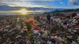 Warga yang berprofesi sebagai pemulung mengumpulkan sampah plastik dengan latar belakang Gunung Gede-Pangrango di Tempat Pembuangan Akhir Galuga, Bogor, Kamis (6/11/2025). Arahan ini bertujuan untuk mencegah pencemaran lingkungan dan penyebaran mikroplastik. (merdeka.com/Arie Basuki)