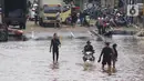 Pengendara dan pejalan kaki melewati perempatan Green Garden, Kedoya, Jakarta, Jumat (3/1/2020). Hingga hari ke-3, banjir masih menggenangi sekitar kawasan perempatan Green Garden, Kedoya akibatnya pengendara harus lebih waspada menghindari mesin kemasukan air. (Liputan6.com/Helmi Fithriansyah)