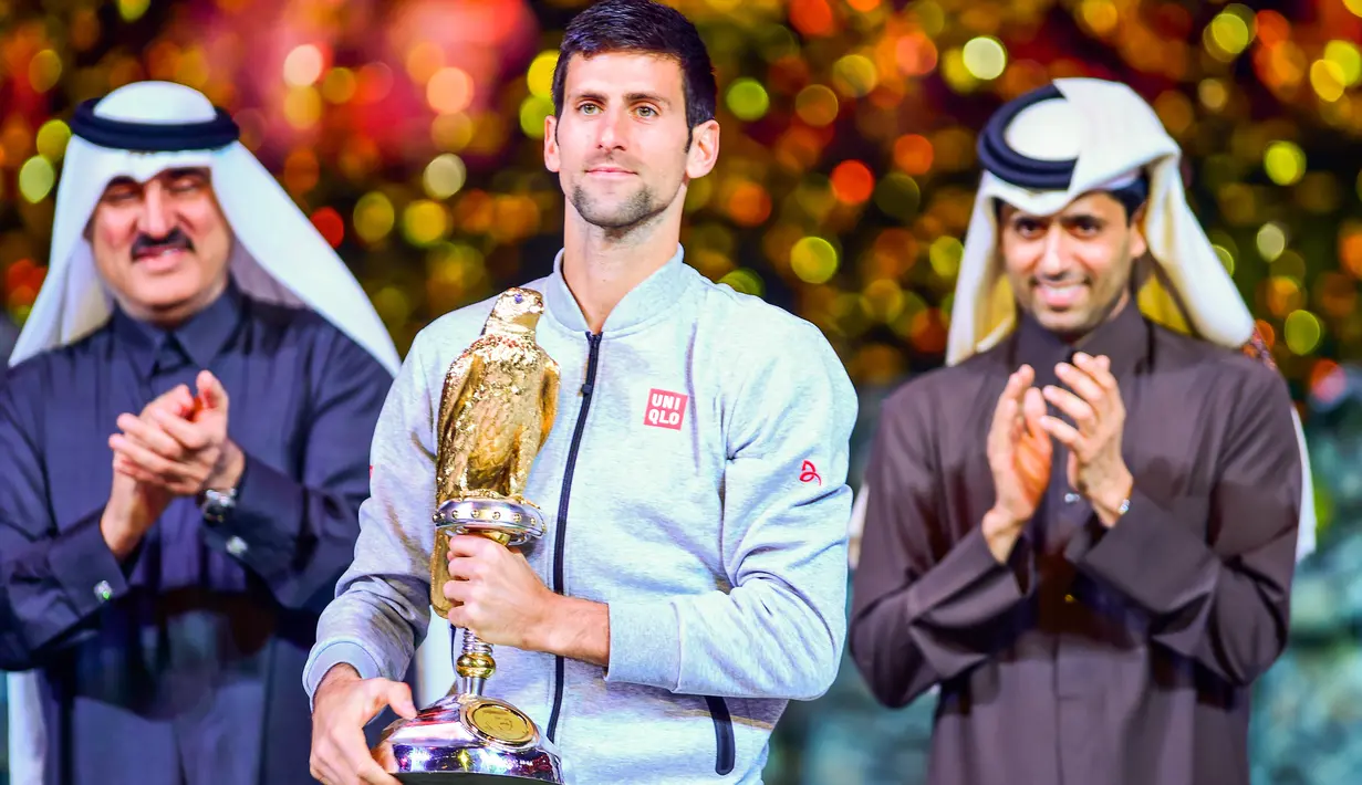 Petenis Serbia, Novak Djokovic memegang trofi Qatar Open 2017 usai menaklukkan petenis Skotlandia, Andy Murray dalam final turnamen Qatar Terbuka di Doha, Sabtu (7/1). Ini merupakan gelar ke-67 buat Djokovic di tur ATP.  (AP Photo/Alexandra Panagiotidou)