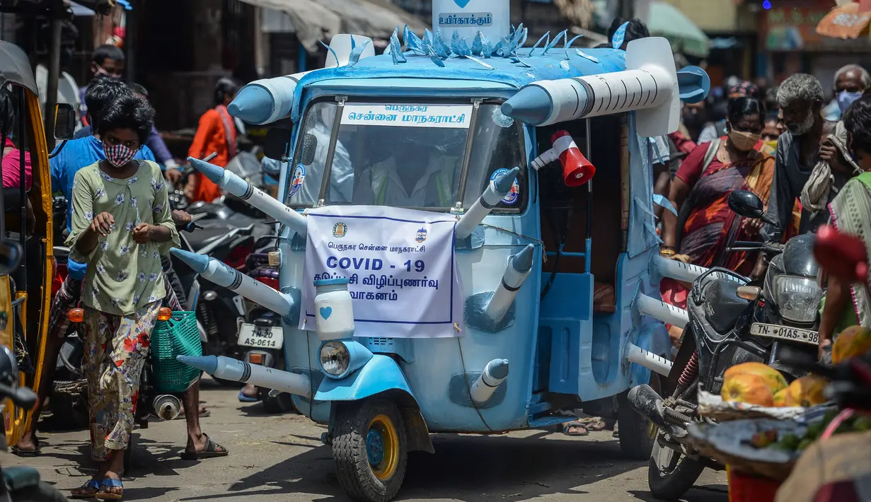 Sebuah bajaj yang dihias dengan replika jarum suntik besar melintasi jalanan di Chennai, India, Sabtu (3/6/2021). Seorang seniman di Chennai menghias bajaj tersebut untuk meningkatkan kesadaran orang-orang tentang pentingnya vaksinasi Covid-19 di tengah sejumlah temuan varian baru. (Arun SANKAR/AFP)