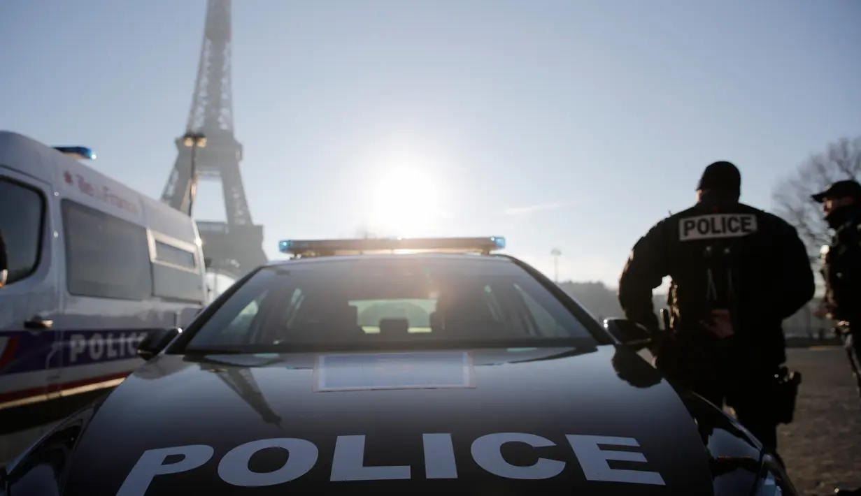 Seorang petugas polisi berpatroli di dekat Menara Eiffel di Paris,  Senin (30/12/2019). Pemerintah Prancis akan mengerahkan 100.000 petugas polisi untuk mengamankan ruang publik pada perayaan malam Tahun Baru di tengah aksi mogok yang sedang berlangsung. (AP/Christophe Ena)